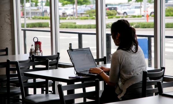 Image of woman on laptop in yxx restaurant